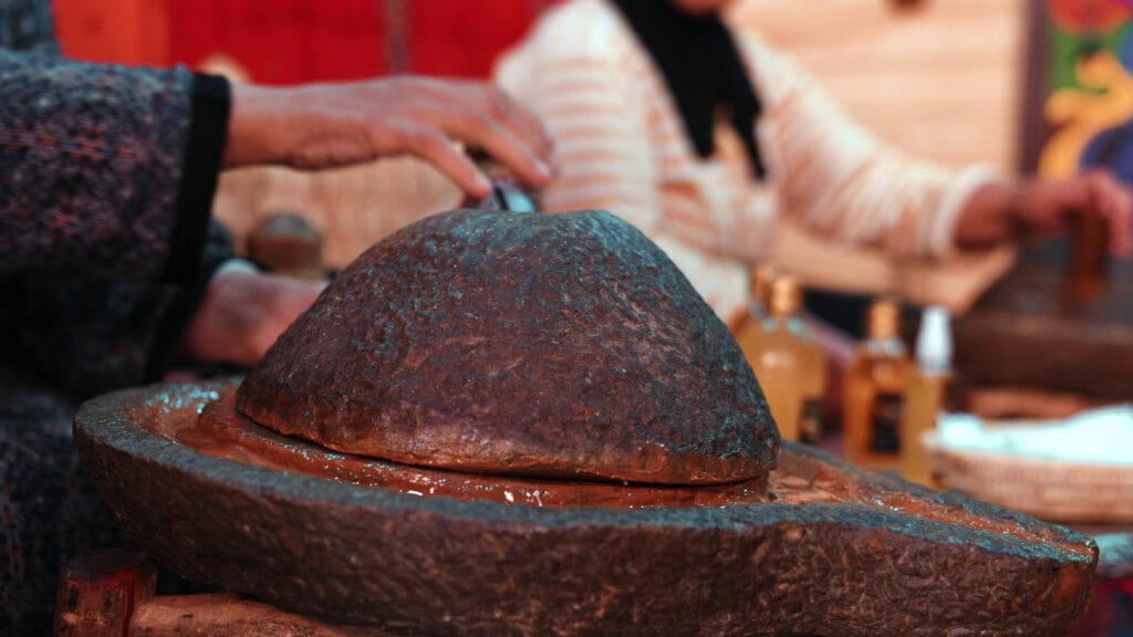 extraction-of-argan-oil-by-traditional-stone-hand-mill-in-morocco-SBI-350431969