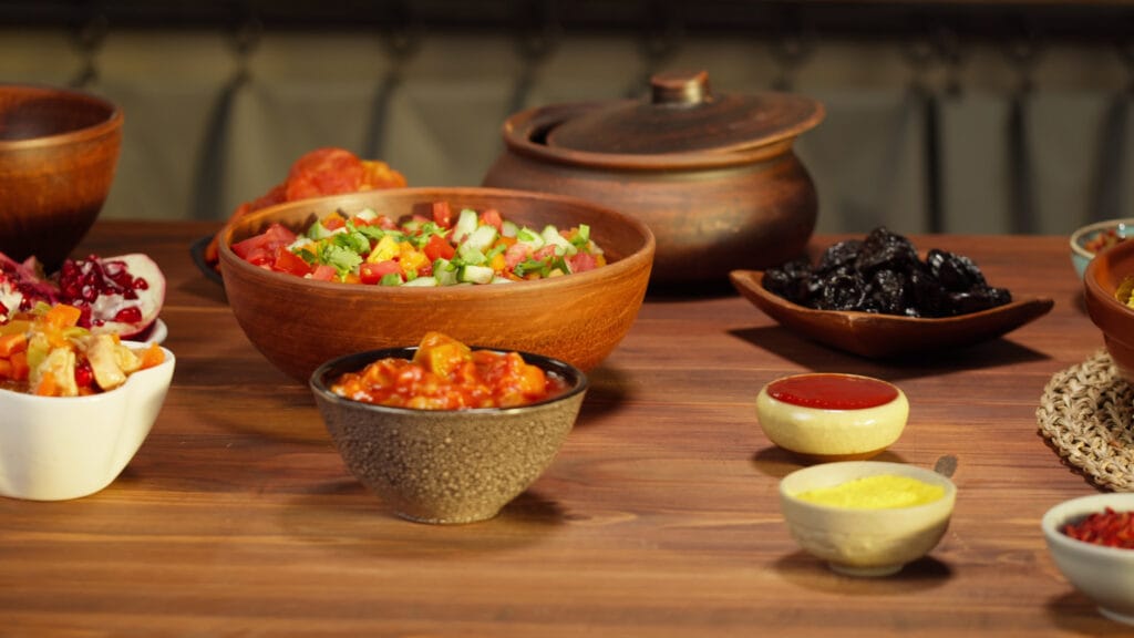 moroccan-cuisine-tajine-traditional-dish-made-of-lamb-and-eggplant-vegetable-salad-mid-SBI-350576812