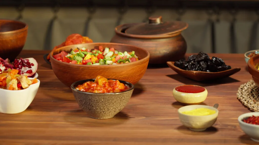 moroccan-cuisine-tajine-traditional-dish-made-of-lamb-and-eggplant-vegetable-salad-mid-SBI-350576812